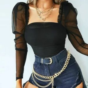 Sheer black blouse with puffy sleeves.